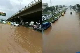 Flooded Accra highway under a bridge with submerged cars